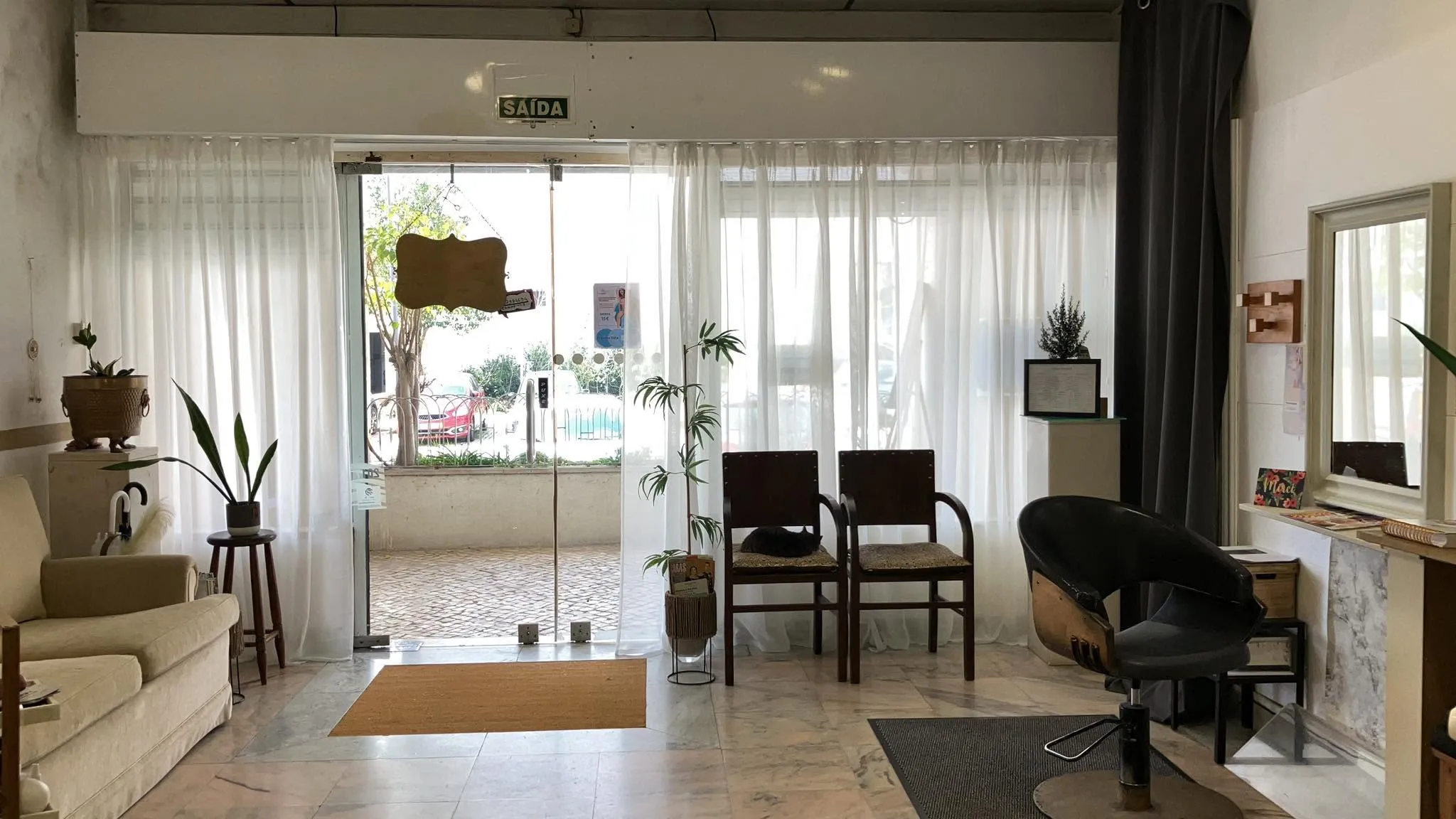 Sala do salão com cadeiras de espera junto à montra